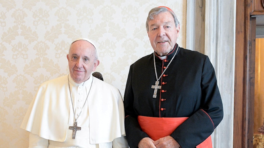 Pope Francis, wearing white robes, and Cardinal Pell,  wearing black robes, pose for a picture.