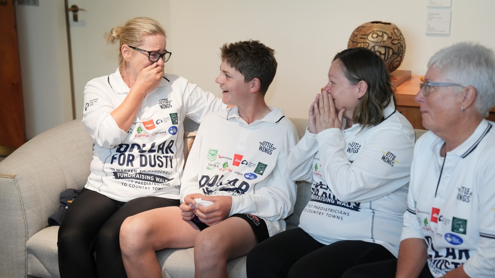 A boy sits shocked while supporters look at him in disbelief.