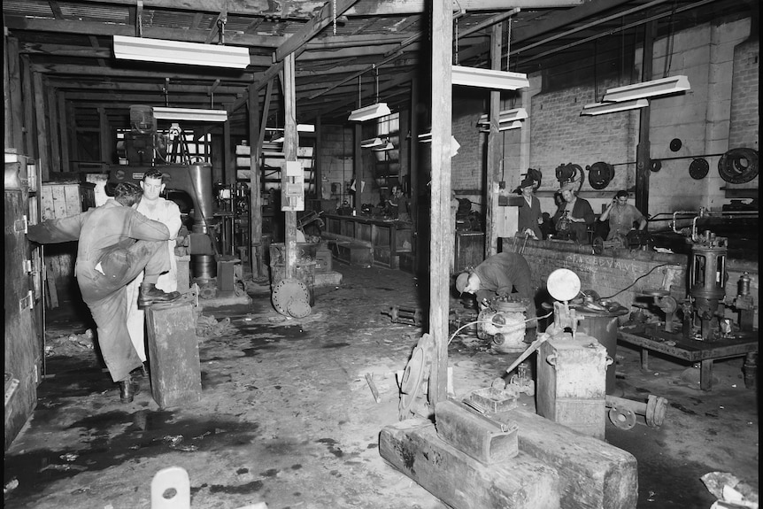 Black and white photograph of men working inside power station 