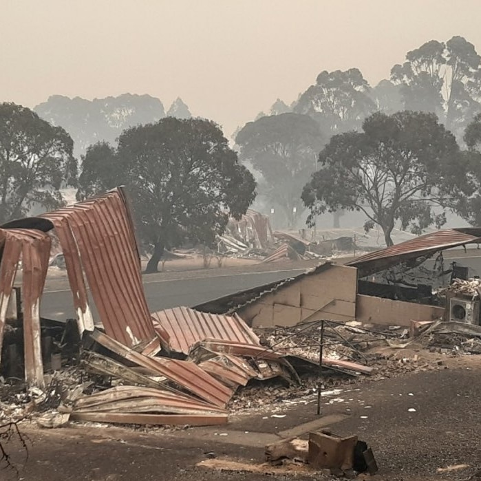 The wreckage of a structure with trees behind