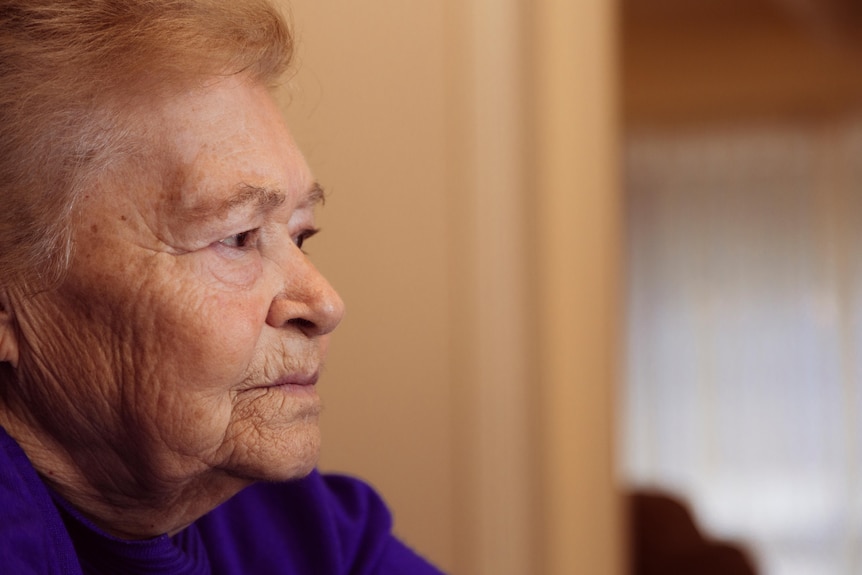 A close up of the side of an elderly woman's face with a serious expression.