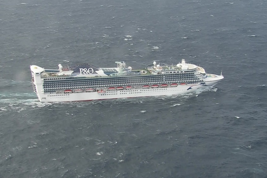 A cruise ship from above surrounded by choppy seas.