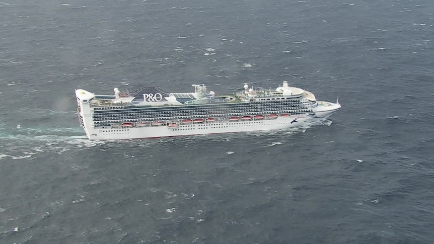 A cruise ship from above surrounded by choppy seas.