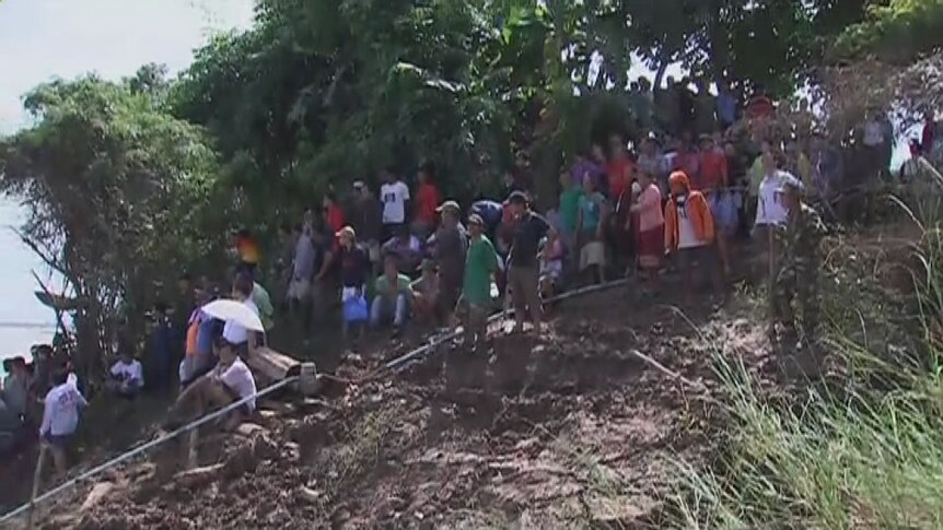 Locals in Pakse watch the rescue operation in the wake of the plane crash.