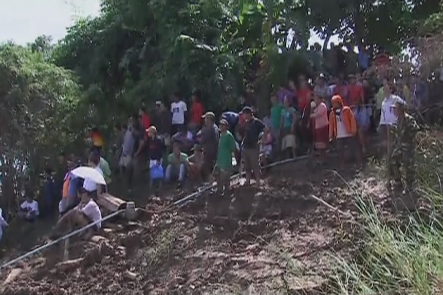 Locals in Pakse watch the rescue operation in the wake of the plane crash.