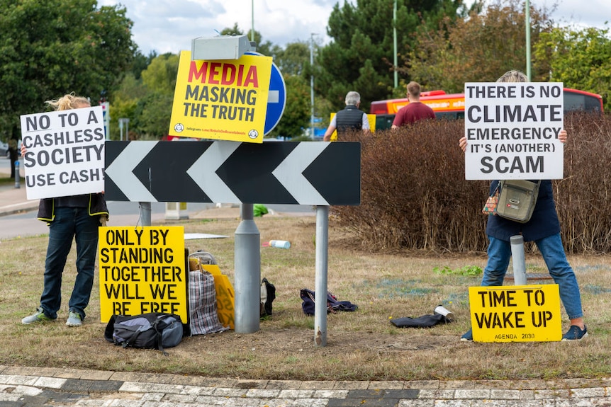 Protest at busy roundabout, Martlesham, Suffolk, England, UK Climate Emergency is a scam, no to cashless society.