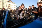 Hamas police inspect destroyed car
