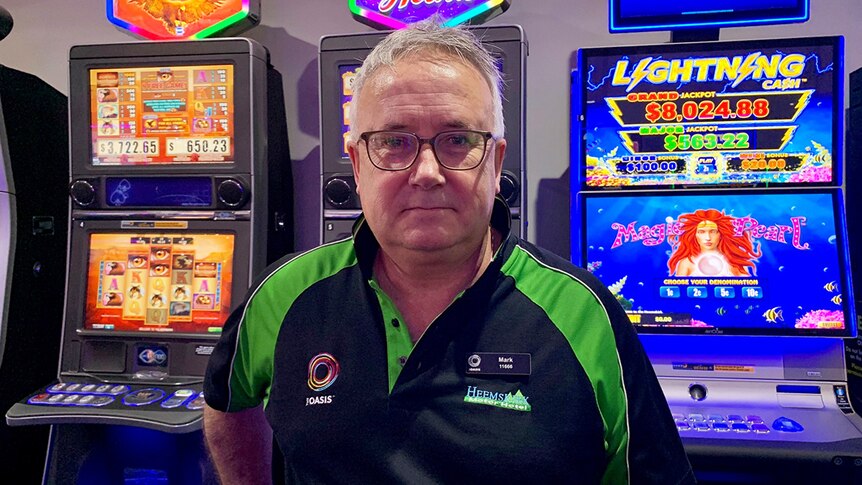 Mark Cleary, gaming operator, stands in front of poker machines.