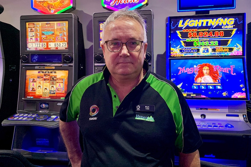 Mark Cleary, gaming operator, stands in front of poker machines.