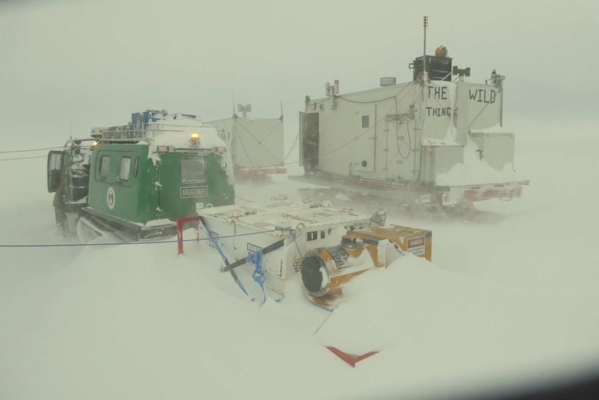 Picture of snow vehicles and a sled covered in snow