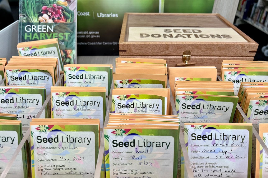 Packets of different seeds with the donation box behind them.
