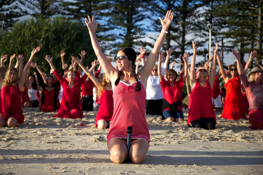 A dancer leads the crowd at a One Billion Rising, V-Day dance on Byron Bay's Main Beach
