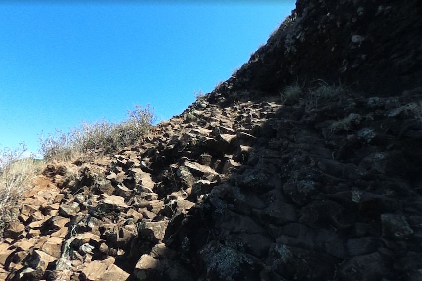 rocky terrain looking upwards towards a mountain top