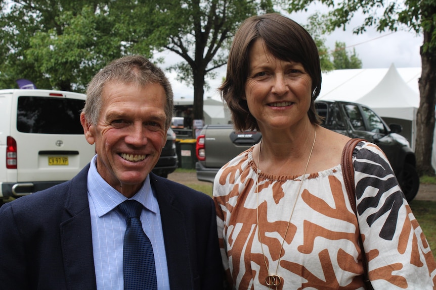Grey haired man and brown haired woman smile next to each other at Bowral Showground