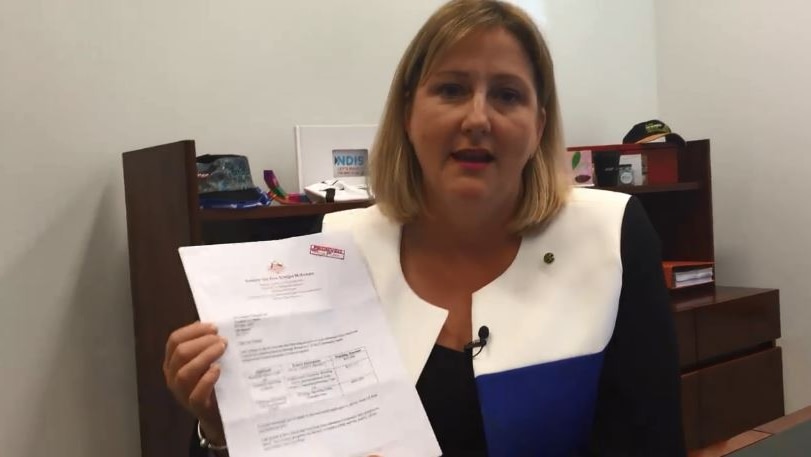 A woman sitting down holding a letter