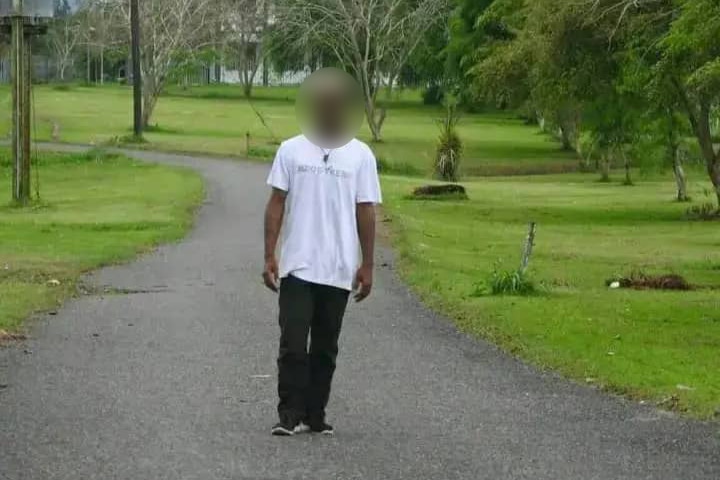 Papua New Guinean man Peter Koma walks down a path in a park