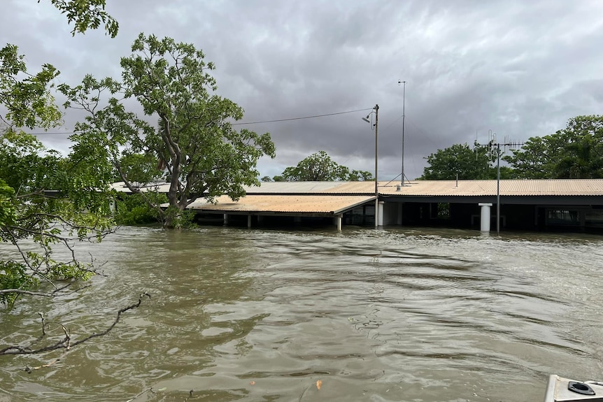 A home inundated by metres of water as dark clouds circle
