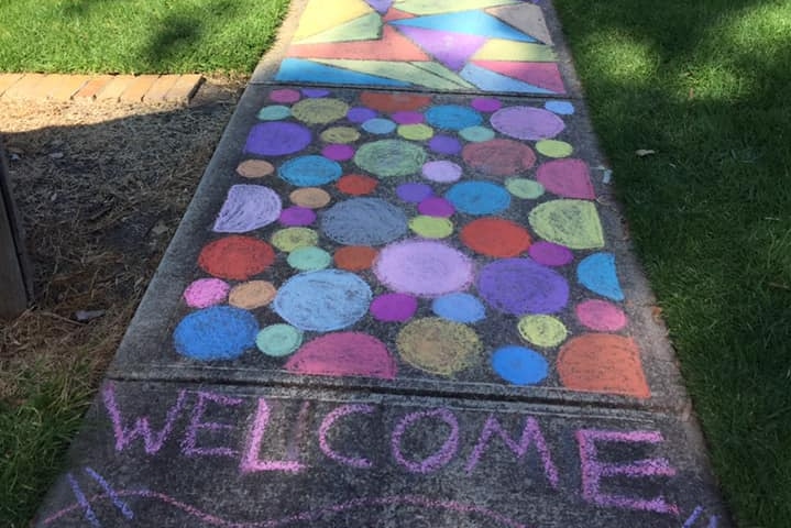 Colourful chalk shapes on a suburban footpath.