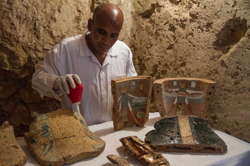 Workers restore funeral furniture found in the tomb.