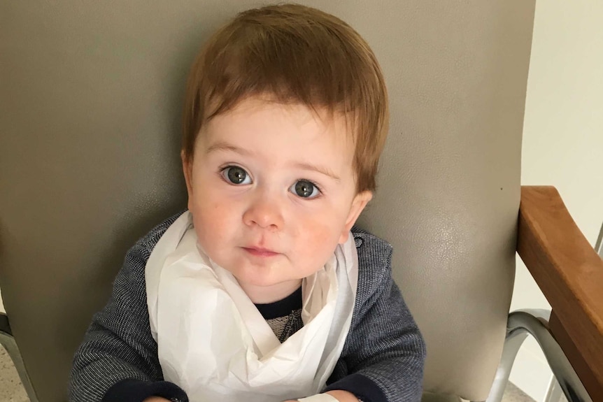 Alfie Chivers sits on a chair in hospital