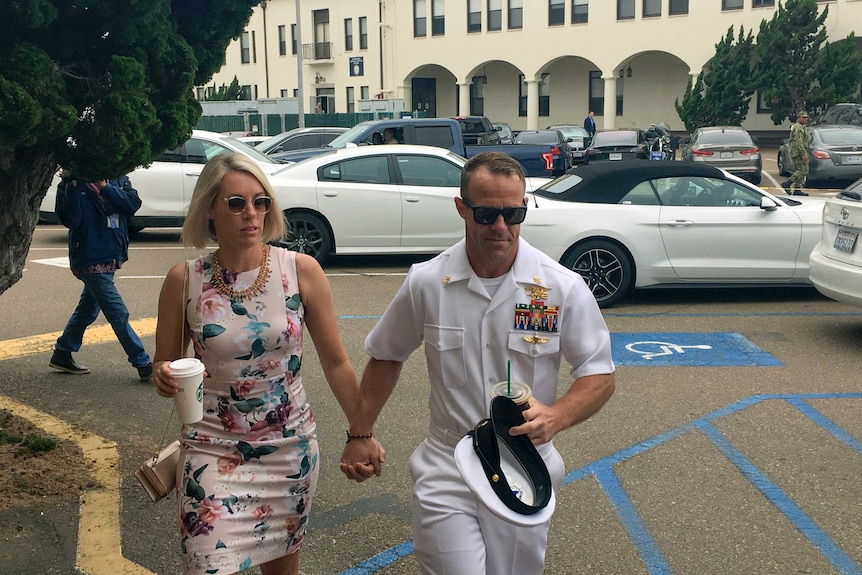 Navy Special Operations Chief Edward Gallagher, right, walks with his wife, Andrea Gallagher, as they arrive to military court