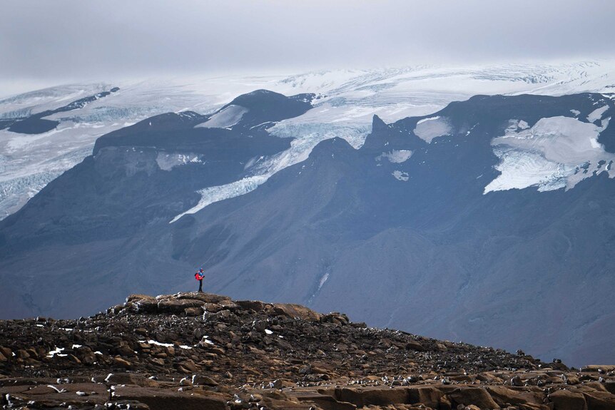 A man stops on his way to the top of what once was the Okjokull glacier, in Iceland.