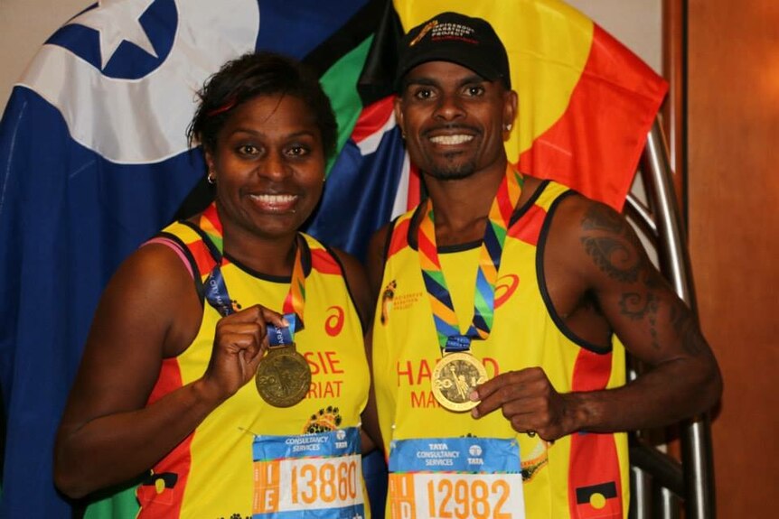 Two indigenous runners proudly hold up their medals after completing the New York Marathon