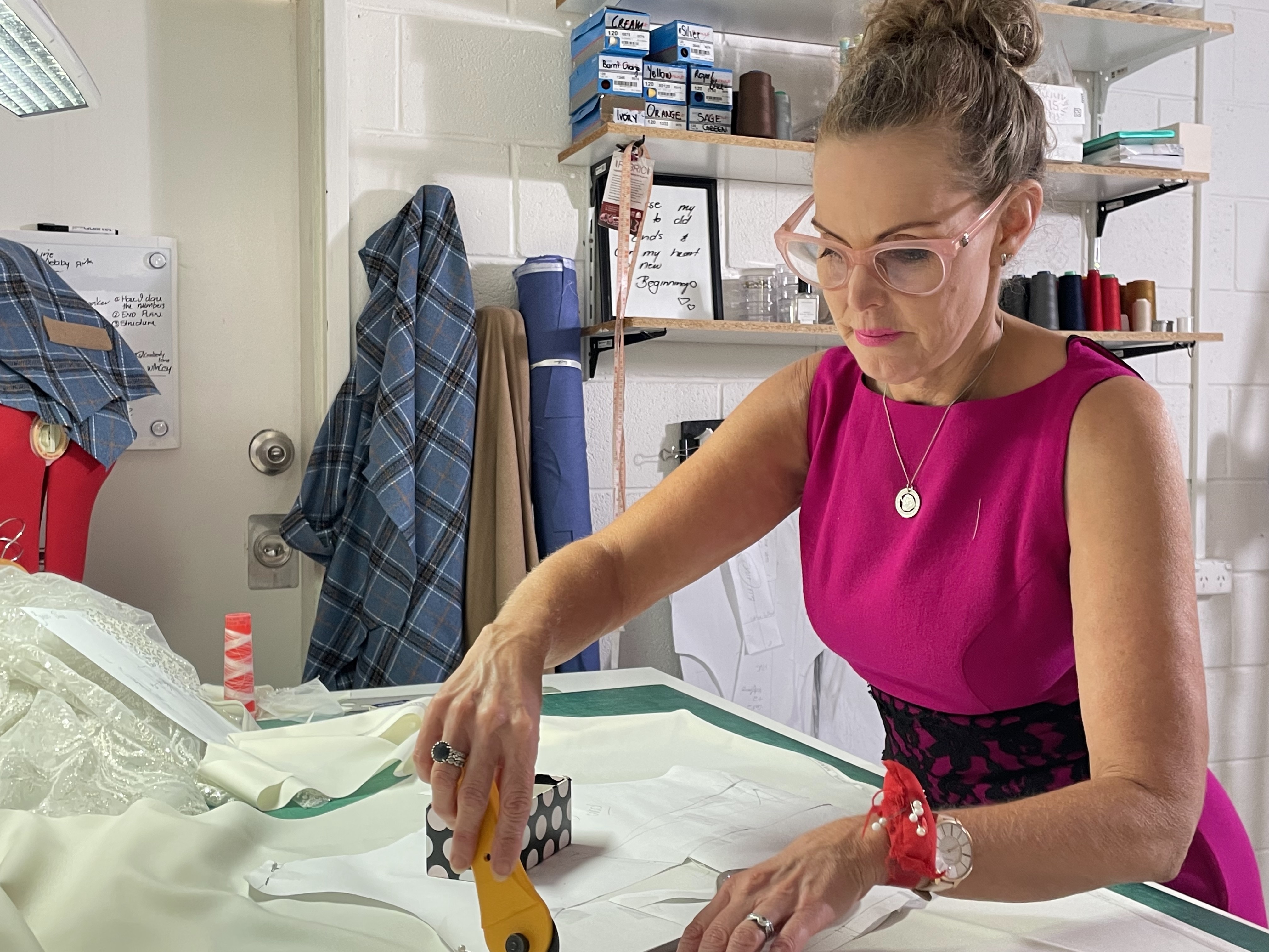Photo of a woman cutting fabric.