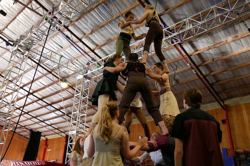 Circus performers practicing a human pyramid.