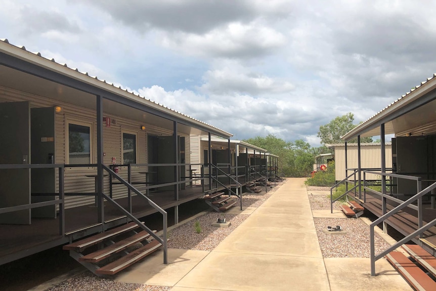 A path flanked by cabins with verandahs at the Howard Springs facility