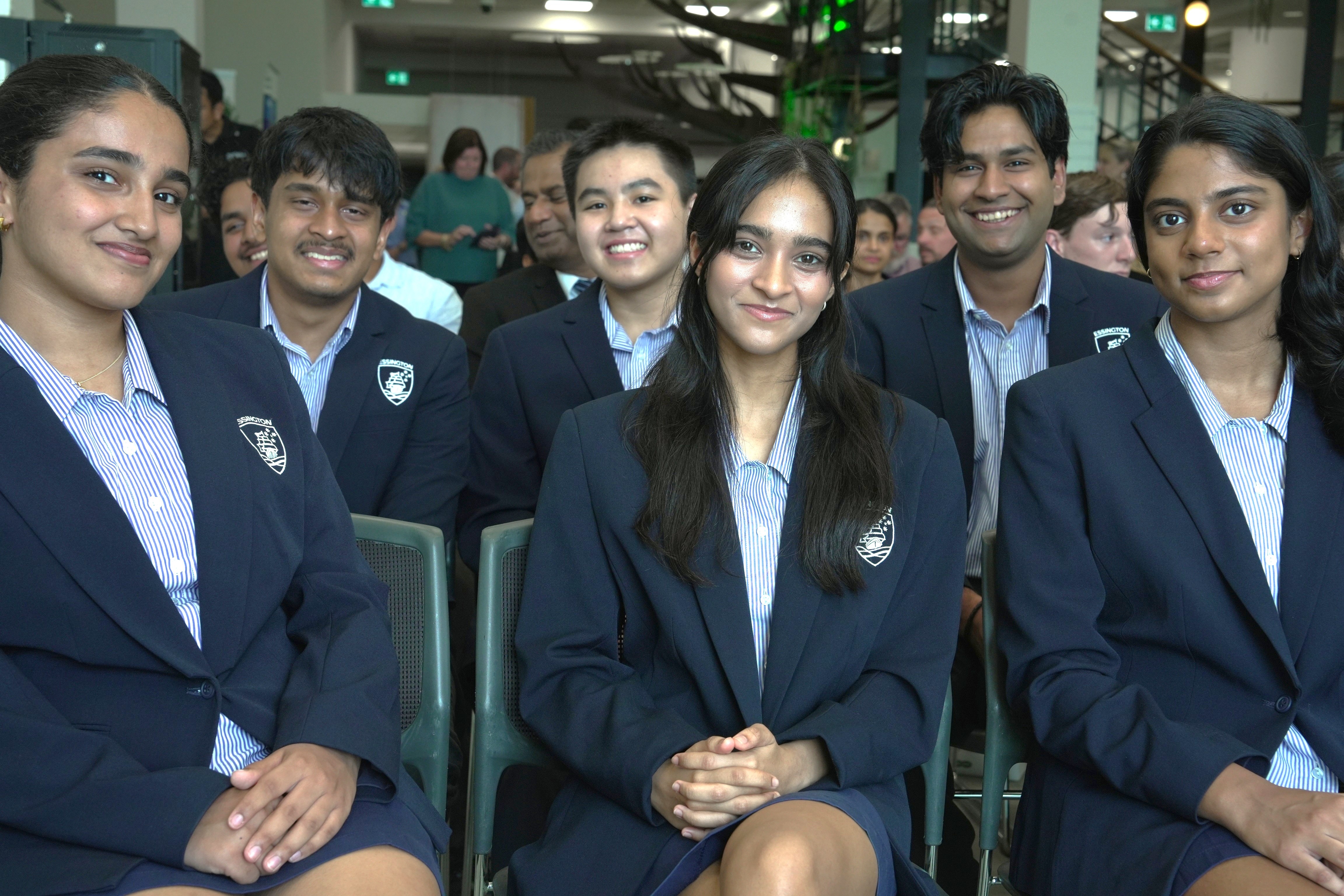 Los estudiantes uniformados se sientan en filas.