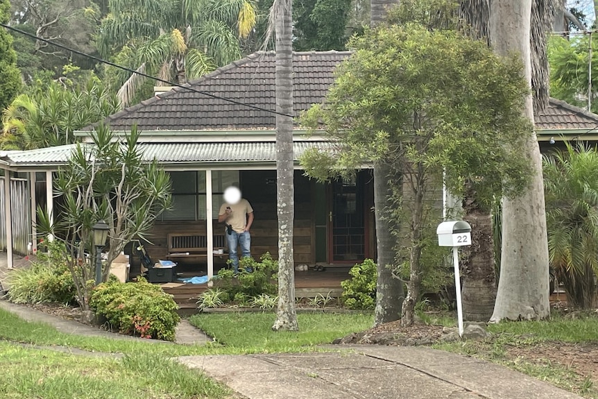 A man stands on the balcony of a home in the suburbs of NSW 