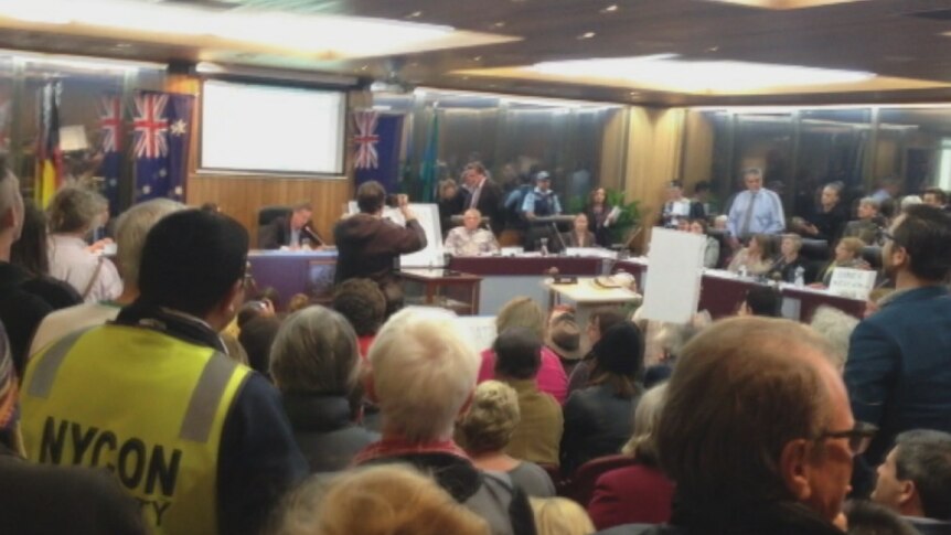 Protesters direct chants towards council officials at the first meeting of the new Inner West Counci.