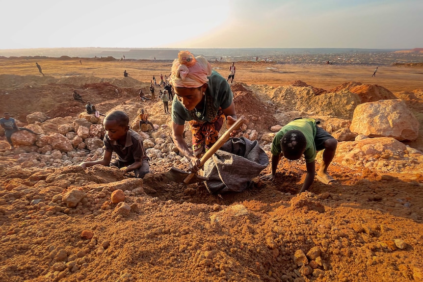 A woman digs with a shovel.