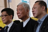 Benny Tai, wearing black rimmed glasses, Chu Yiu-ming, with white hair, and Chan Kin-man look off into the distance.