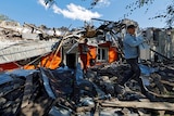 Men remove debris of a building destroyed by recent shelling during Russia-Ukraine conflict i