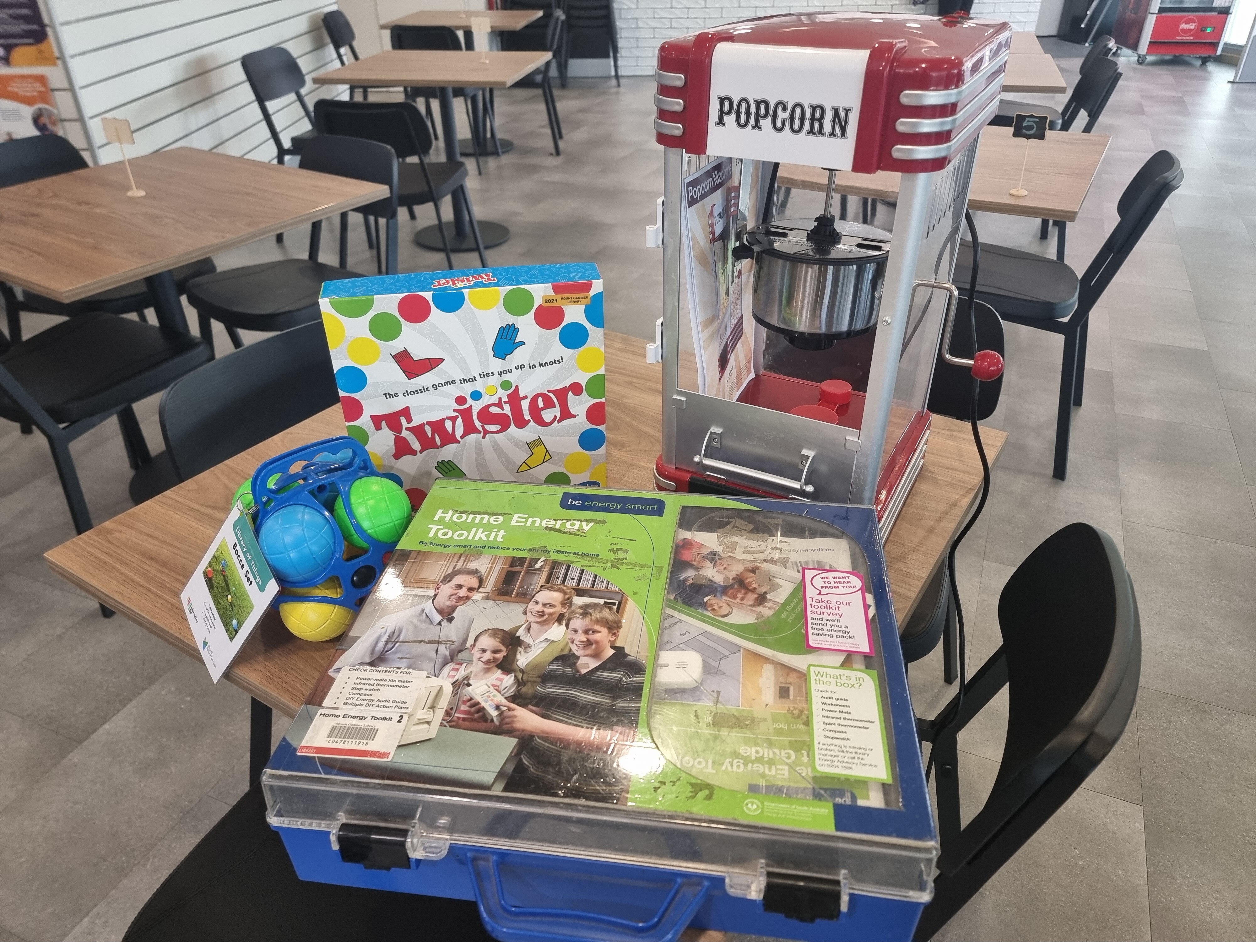 A bocce set, game of Twister, home energy toolkit and popcorn machine sitting on a table