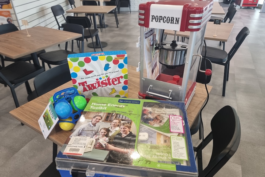 A bocce set, game of Twister, home energy toolkit and popcorn machine sitting on a table