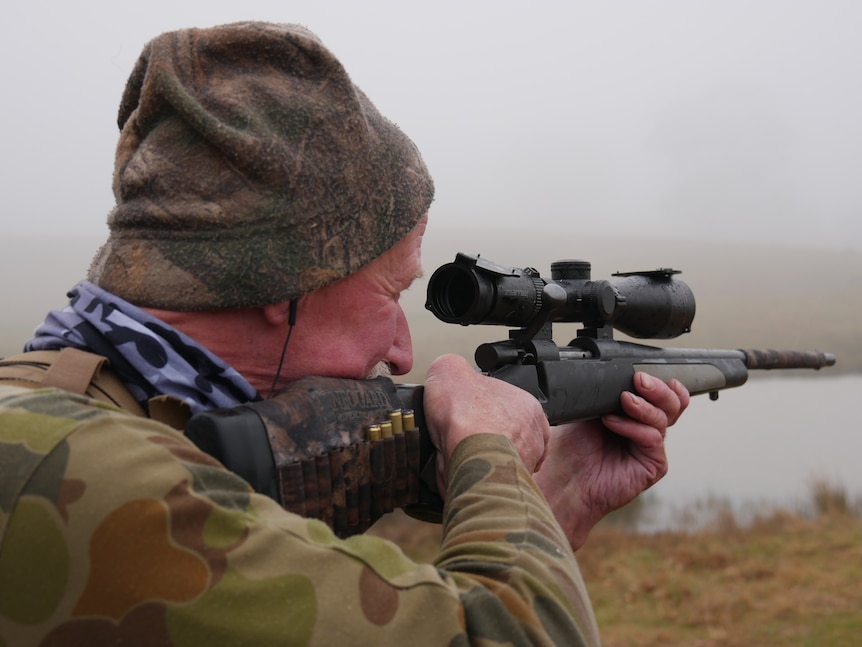 A man aims a gun.