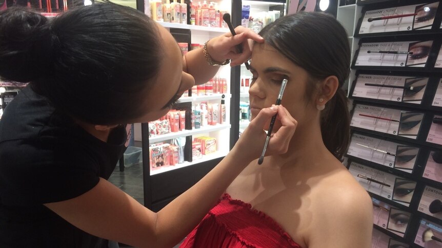 Makeup artist applies makeup to model