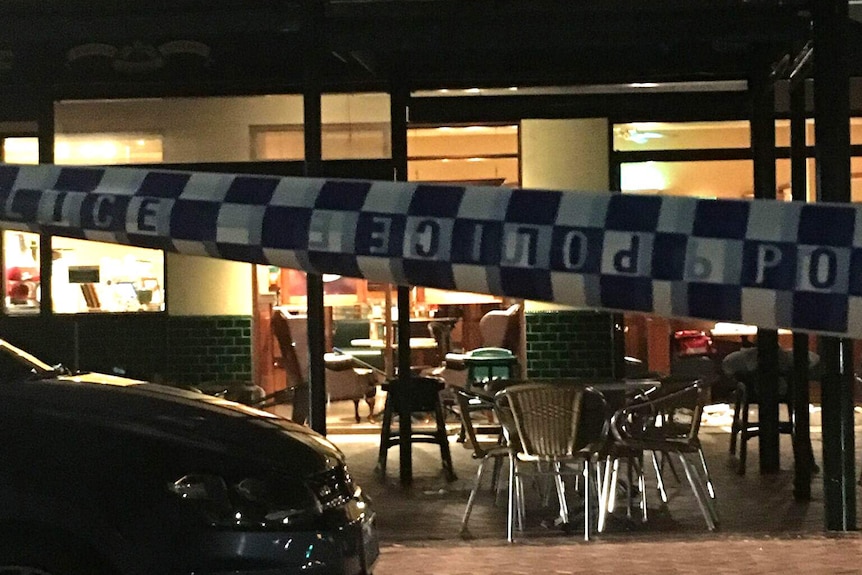 A Dome Cafe at night cordoned off by police tape.