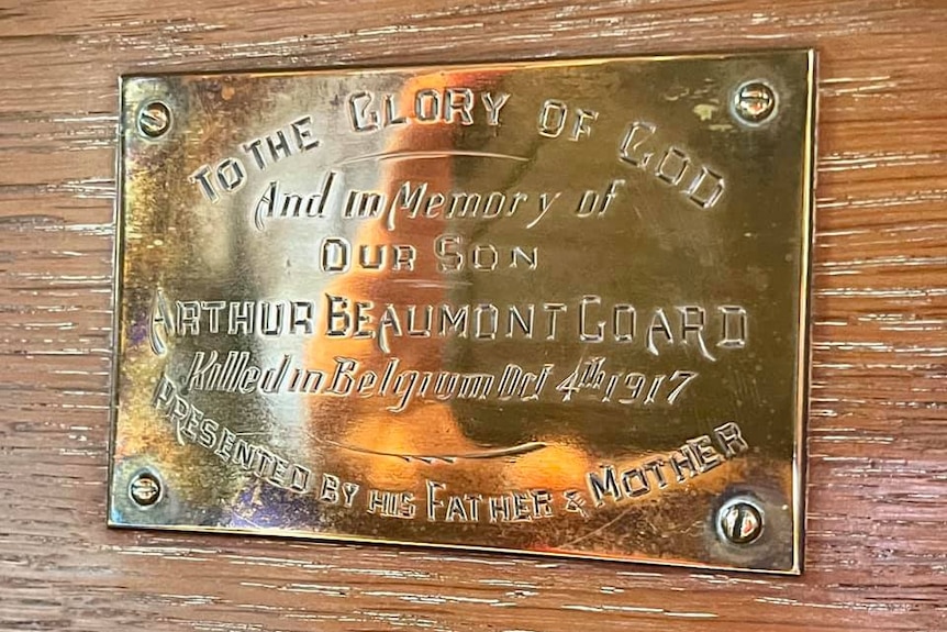 A plaque in memorial of Arthur Beaumont Goald on a wooden wall.