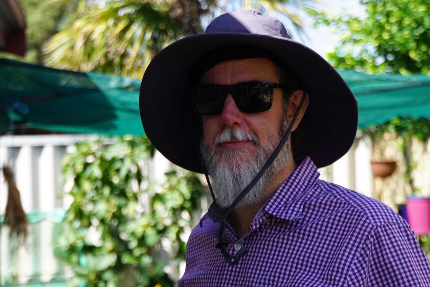 Perth man Scott Dunning wearing a hat in his garden