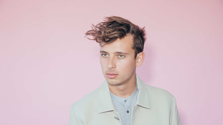 Australian producer Flume, in front on a pink background