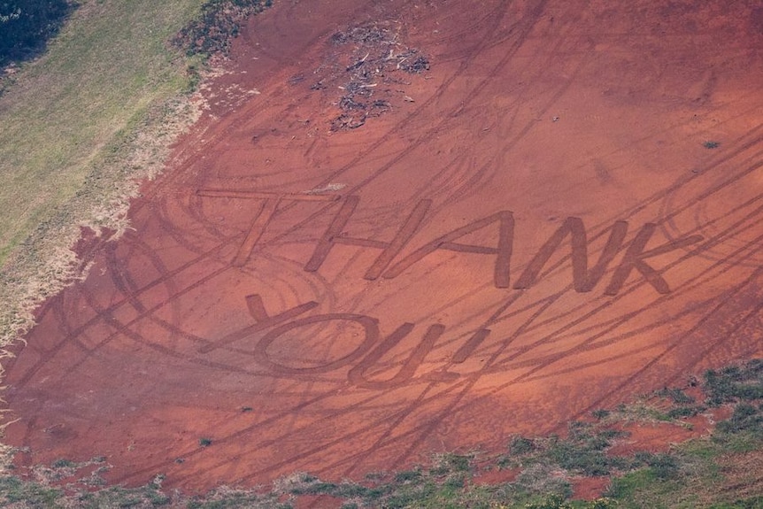 An aerial shot shows Thank You written near a patch of blackened earth during bushfires.