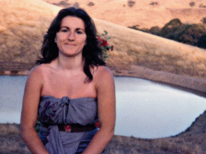 A young Vicki Cleary sits on a fence on a bush property.