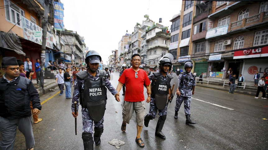 Nepalese police personnel detain a protester during a an anti-charter strike