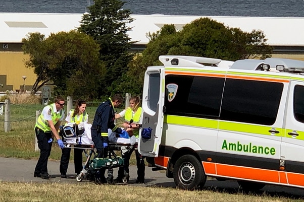 Driver injured in a fatal crash is put into an ambulance