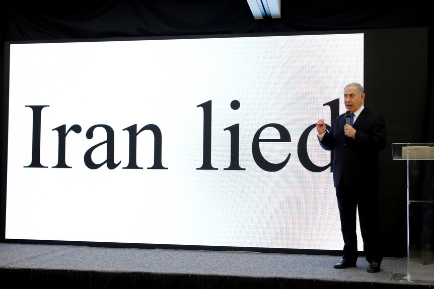 Benjamin Netanyahu stands in front of a big digital display that reads "Iran lied".
