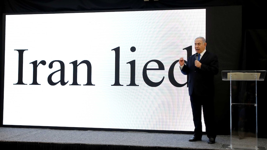 Benjamin Netanyahu stands in front of a big digital display that reads "Iran lied".